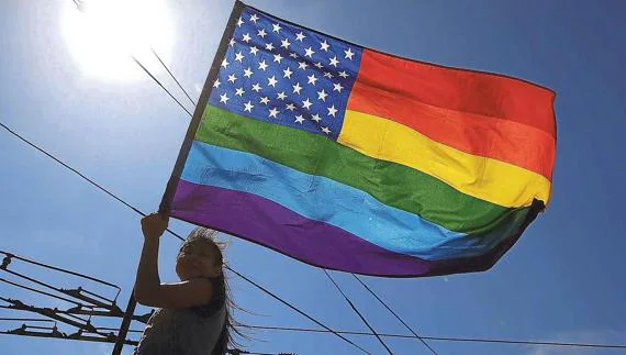 Una mujer ondea la bandera del orgullo gay en San Francisco.
