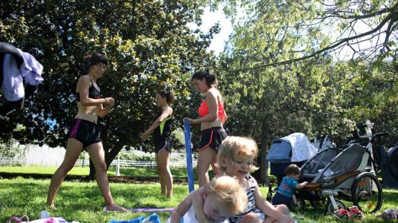 Varios niños y los mayores que les cuidan se divierten a la sombra, en un parque de Bilbao, que registró temperaturas por encima de los 40 grados.