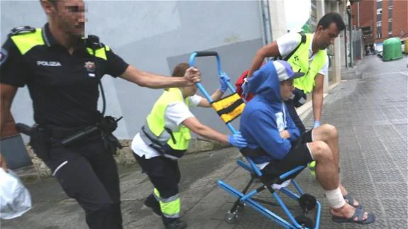 Sanitarios y policías trasladan a una ambulancia al detenido por apuñalamiento, que también resultó herido.
