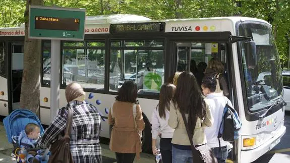 Varios viajeros suben a un urbano en una de las paradas de Vitoria con paneles digitales.
