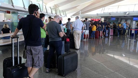 Pasajeros esperan a facturar en el Aeropuerto de Bilbao. 