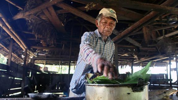 Un hombre de la etnia ticuna prepara un remedio con hierbas medicinales.