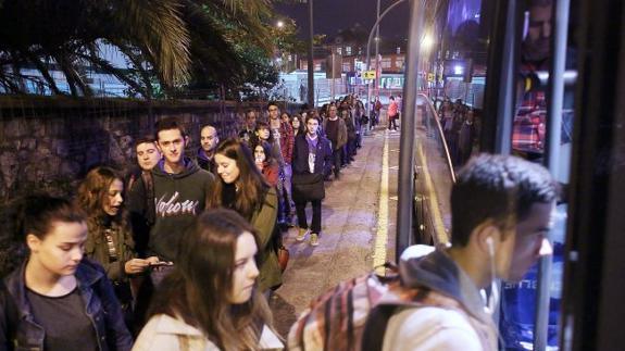 La cola de estudiantes para tomar el bus universitario se extiende a lo largo de la calle Pérez Galdós, en un lateral de Termibus.