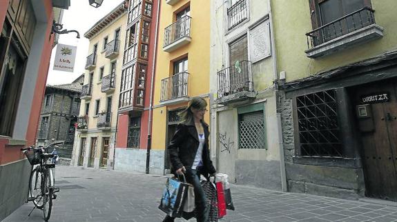 Una mujer camina cargada de bolsas por la calle Chiquita del Casco Medieval.
