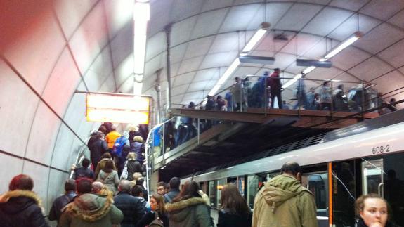 Varios pasajeros en los andenes del metro.