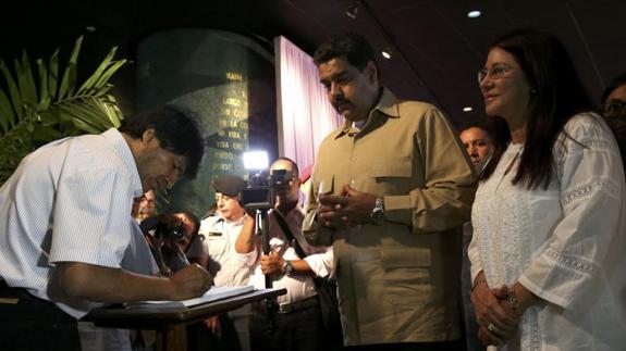 El presidente venezolano, Nicolás Maduro, y el boliviano Evo Morales, firman en el libro de condolencias.