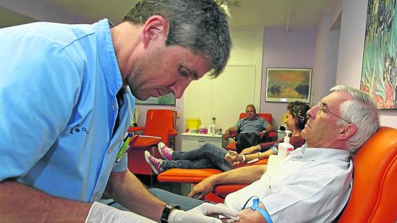 Un sanitario coloca la aguja para extraer sangre a un donante. 