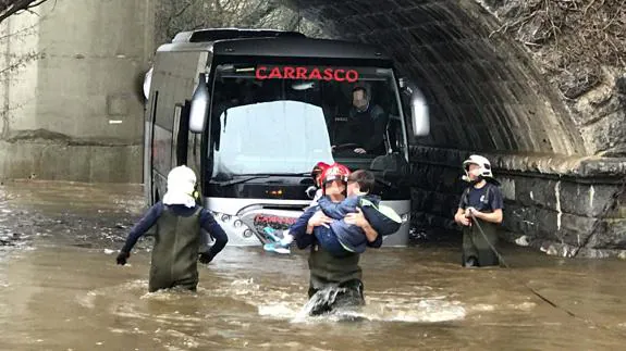 Un bombero saca a un menor del autobús