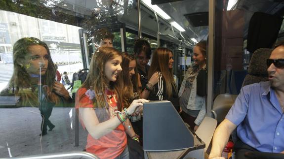 Unas estudiantes cancelan su billete en un bus de Vitoria