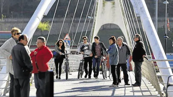 Vecinos de distintas edades pasean por el puente Calatrava de Ondarroa.