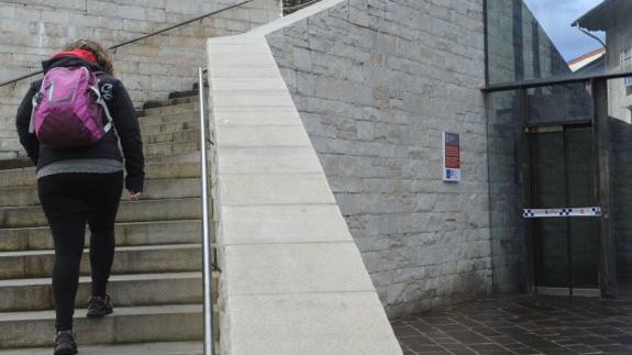 Una mujer sube las escaleras hacia la plaza de Santa María ante una avería del ascensor.