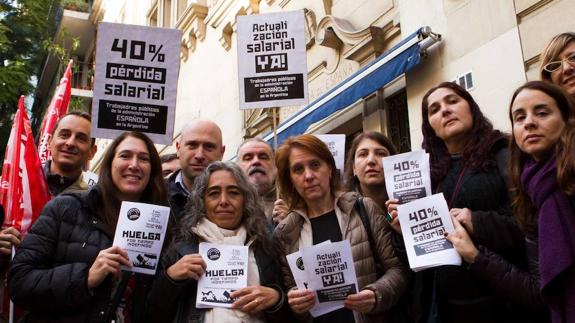 Miembros del personal laboral de la Embajada de España en Buenos Aires muestran carteles de la huelga.