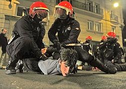 Dos Ertzaintzas detienen a uno de los manifestantes. / Igor Aizpuru