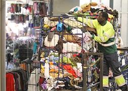 Un operario transporta un montón de ropa para su posterior reciclaje. / Pedro Urresti| Vídeo: Lara Bermúdez/ Amaia Hueso