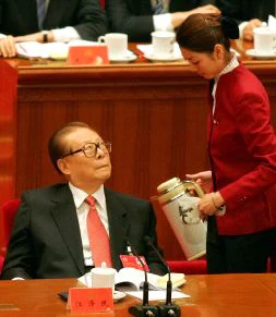 TAZA DE TÉ. El ex presidente chino, Jiang Zemin, observa a una azafata en el congreso comunista. / AP