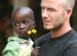 David Beckham, embajador de Unicef, con un niño en brazos en Sierra Leona. / AFP