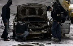 Ertzainas, entre ellos de la Policía científica, examinan el coche de un escolta atacado por ETA. / L. A. GÓMEZ