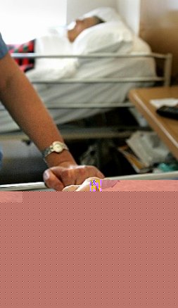 Una enfermera coge de la mano a un paciente. / E. C.