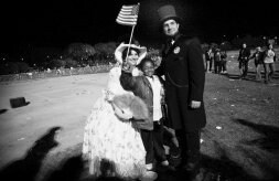 Un seguidor de Obama, vestido de Abraham Lincoln, junto a una mujer y un niño, celebra el triunfo del afroamericano en el parque Grant.