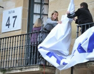 La hermana del capitán retira la pancarta que pedía la liberación de los arrantzales. / F. GÓMEZ