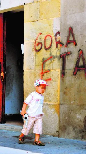 Un niño juega debajo de una pintada en favor de ETA en un municipio vasco. :: F. GÓMEZ
