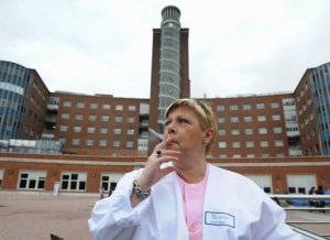Una auxiliar fuma ante la fachada del hospital de Cruces, fuera del recinto para evitar sanciones. ::                             BORJA AGUDO
