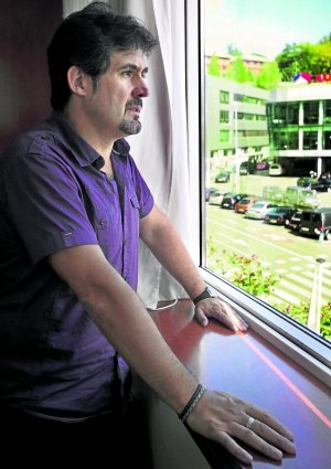 Pello Urizar se asoma a la ventana de la sede de Eusko Alkartasuna en el barrio donostiarra de Igara. :: LUIS MICHELENA