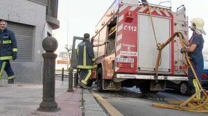 Los Bomberos despliegan la manguera ante la imposibilidad de acceder al portal «por los bolardos». ::                         FOTOS: LUIS CALABOR