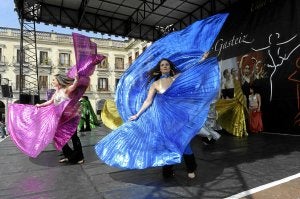 Integrantes del grupo de danza 'Gisela' ejecutan una vistosa coreografía en la plaza de España./ IGOR AIZPURU