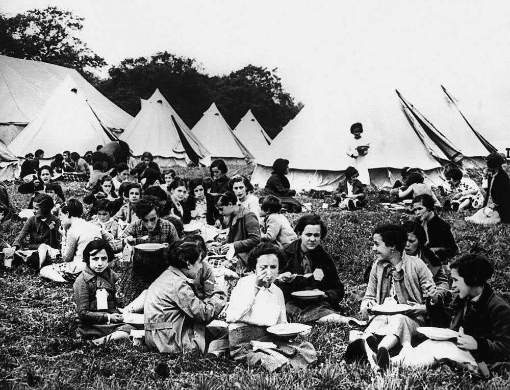 Niños refugiados españoles comen en el campamento de Stoneham (Reino Unido) a finales de mayo de 1937, tras ser evacuados desde Bilbao a bordo del buque "La Habana". Tras llegar al puerto de Southampton y pasar una inspección médica, fueron trasladados en autobús a este campamento, en el que permanecieron varias semanas antes de ser acogidos por familias.