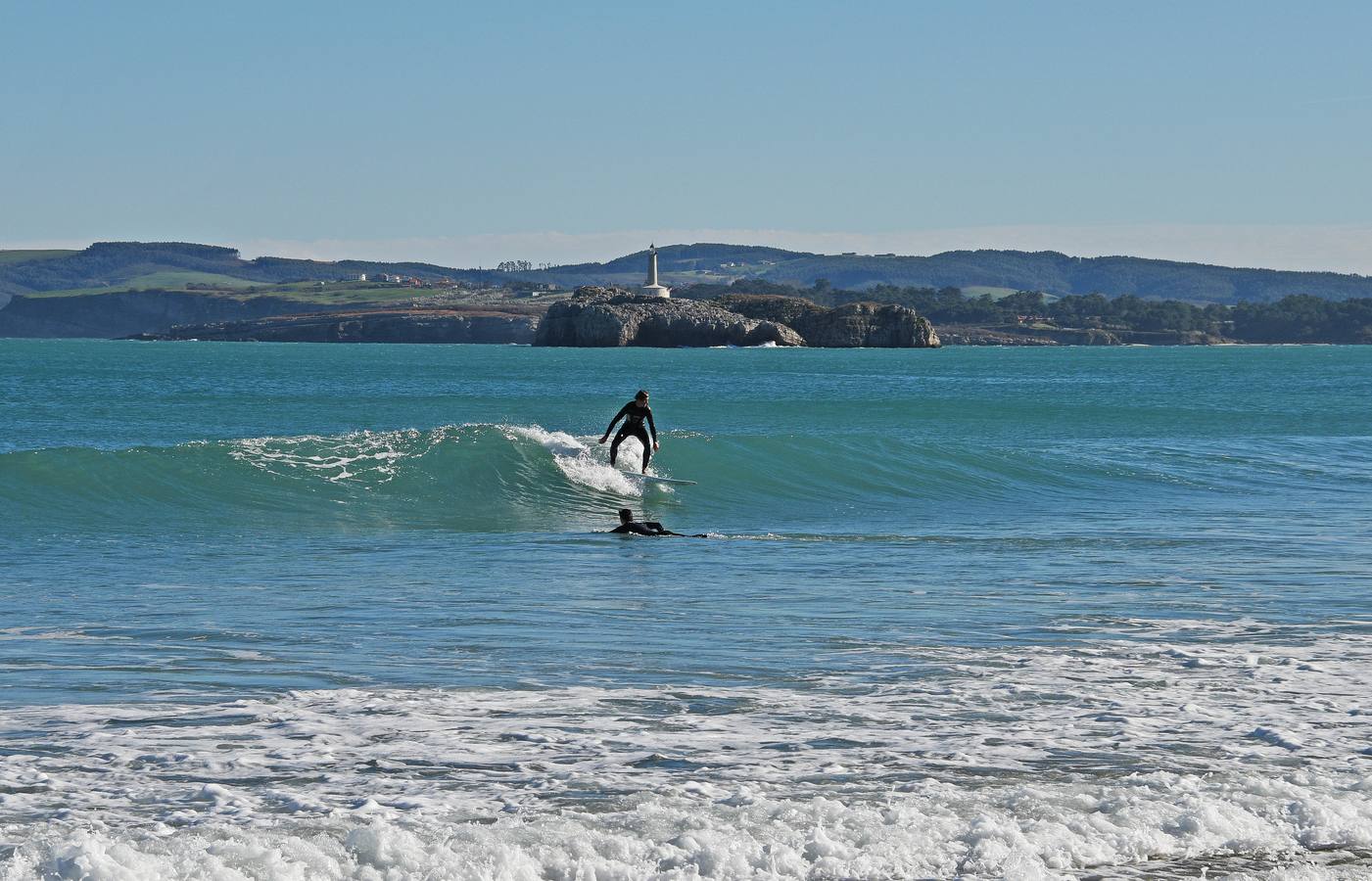 Dos surfistas en la playa de El Sardinero. Al fondo, la isla de Mouro