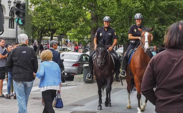 Dos policías nacionales pasean con sus caballos por la Avenida de CalvoSotelo tras la presentación del servicio