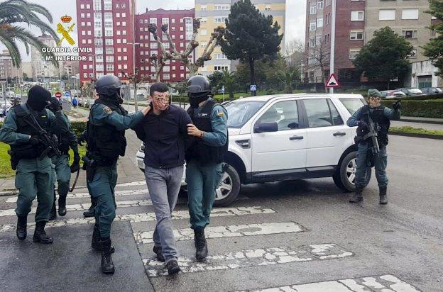 Imagen de archivo de un grupo de agentes mientras trasladan a un detenido durante una operación contra el robo en viviendas de Cantabria.