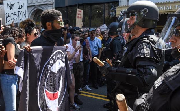 Un manifestante y un antidisturbios se encaran.