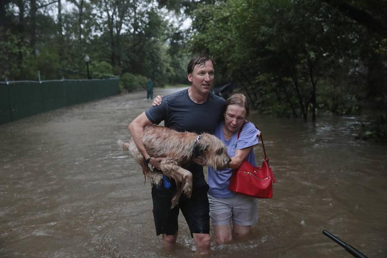 Andrew White (Iz) ayuda a una vecina después de rescatarla de su casa en su barco