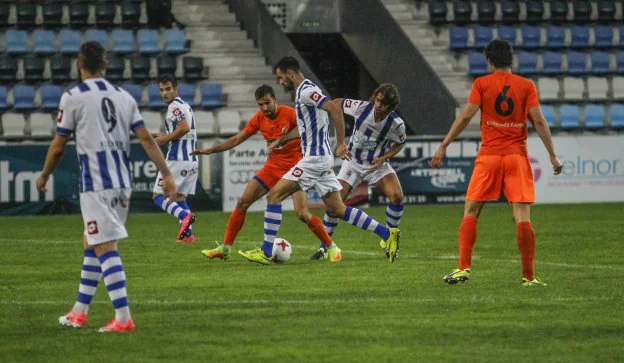 Cagigas conduce el balón ante un rival, apoyado por Luis Alberto y Vitienes, a la izquierda. 