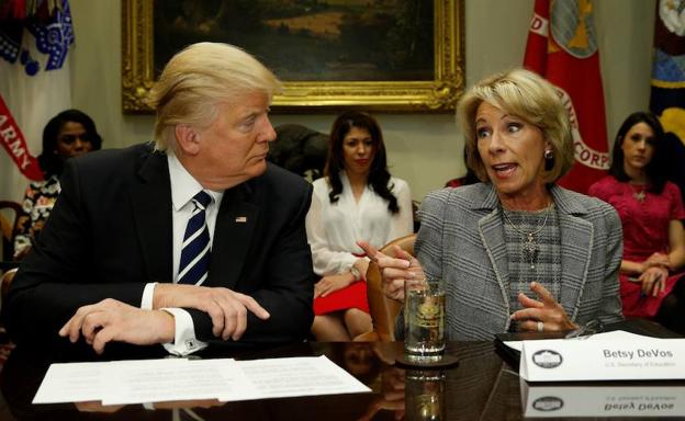 Donald Trump (i.) y Betsy DeVos (dcha.).