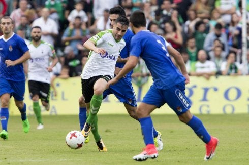 Óscar Fernández conduce la pelota ante dos contrarios. 