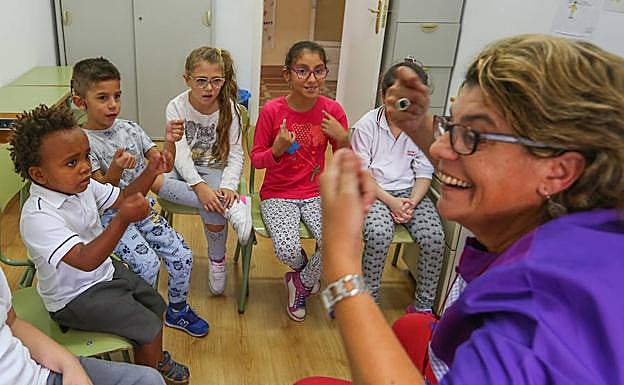 ignos. María Ángeles García  enseña lengua de signos a un grupo de niños en el Colegio Sagrada Familia de Granada