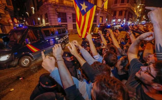 Manifestantes en Barcelona ante un furgón policial.