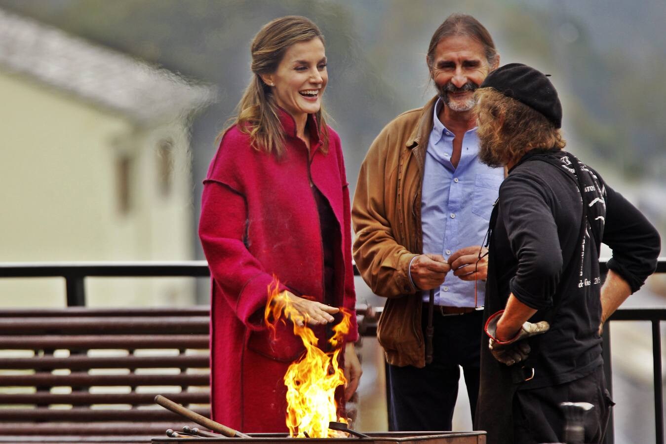 La reina Letizia se calienta las manos en el fuego de una fragua durante su visita a la comarca de Los Oscos (Asturias) con motivo de la entrega del Premio al Pueblo Ejemplar de Asturias 2016. (Foto: Alberto Morante)