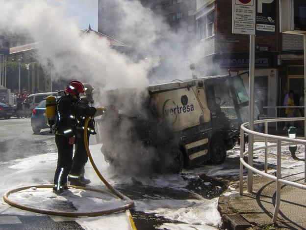 Los bomberos de Castro Urdiales sofocan el incendio de una barredora en el centro de la ciudad.