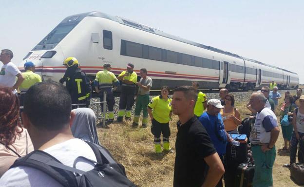 Imagen principal - Arriba: pasajeros tirados tras arder un vagón en el tren Madrid-Badajoz el pasado 13 de julio. Debajo: Estación de Cárceres con trenes diésel modelo R-598, el más habitual en Extremadura. Detalle de una vía del año 1886, en Usagre (Badajoz).