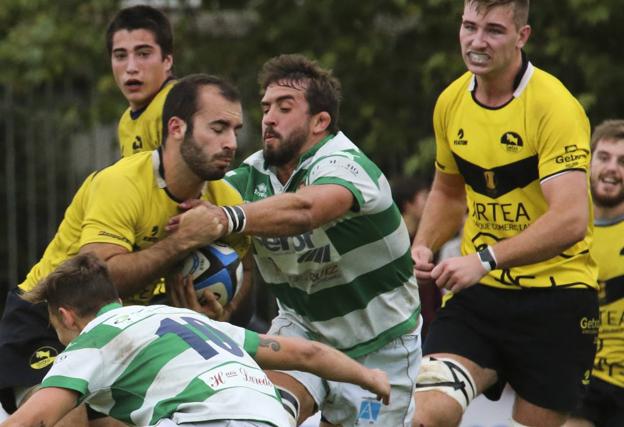 'Juanpi' Guido lucha por el balón con un jugador del Getxo en el partido que jugó el Senor en Fadura.