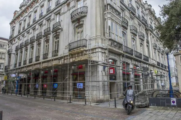 El edificio, con fachada principal a la Plaza de Pombo, tienen andamios para defender a los peatones de caídas de piezas de la fachada. 