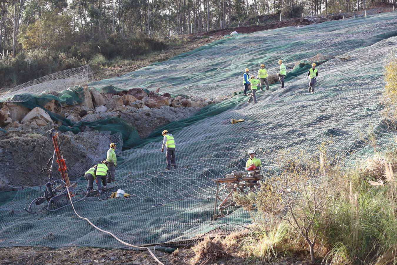 Las máquinas y el personal trabajan para despejar los dos carriles cortados por un argayo a la altura de Caviedes