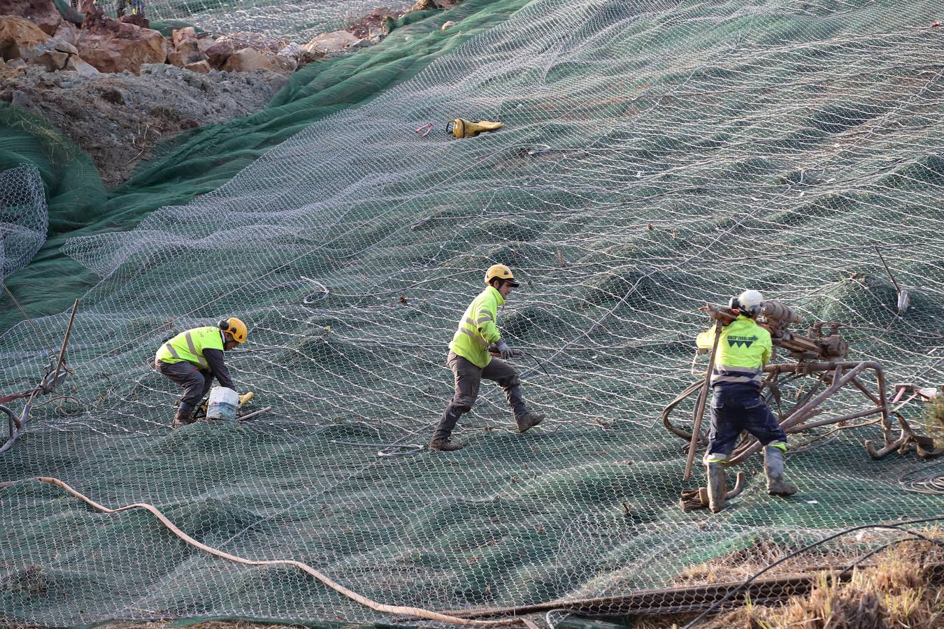 Las máquinas y el personal trabajan para despejar los dos carriles cortados por un argayo a la altura de Caviedes