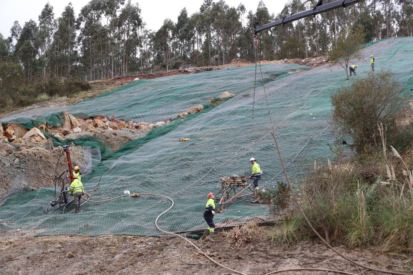 Las máquinas y el personal trabajan para despejar los dos carriles cortados por un argayo a la altura de Caviedes