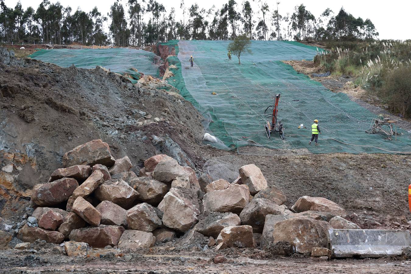 Las máquinas y el personal trabajan para despejar los dos carriles cortados por un argayo a la altura de Caviedes