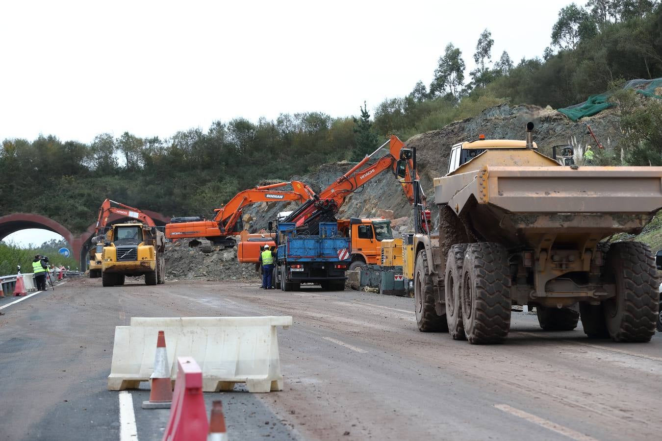 Las máquinas y el personal trabajan para despejar los dos carriles cortados por un argayo a la altura de Caviedes